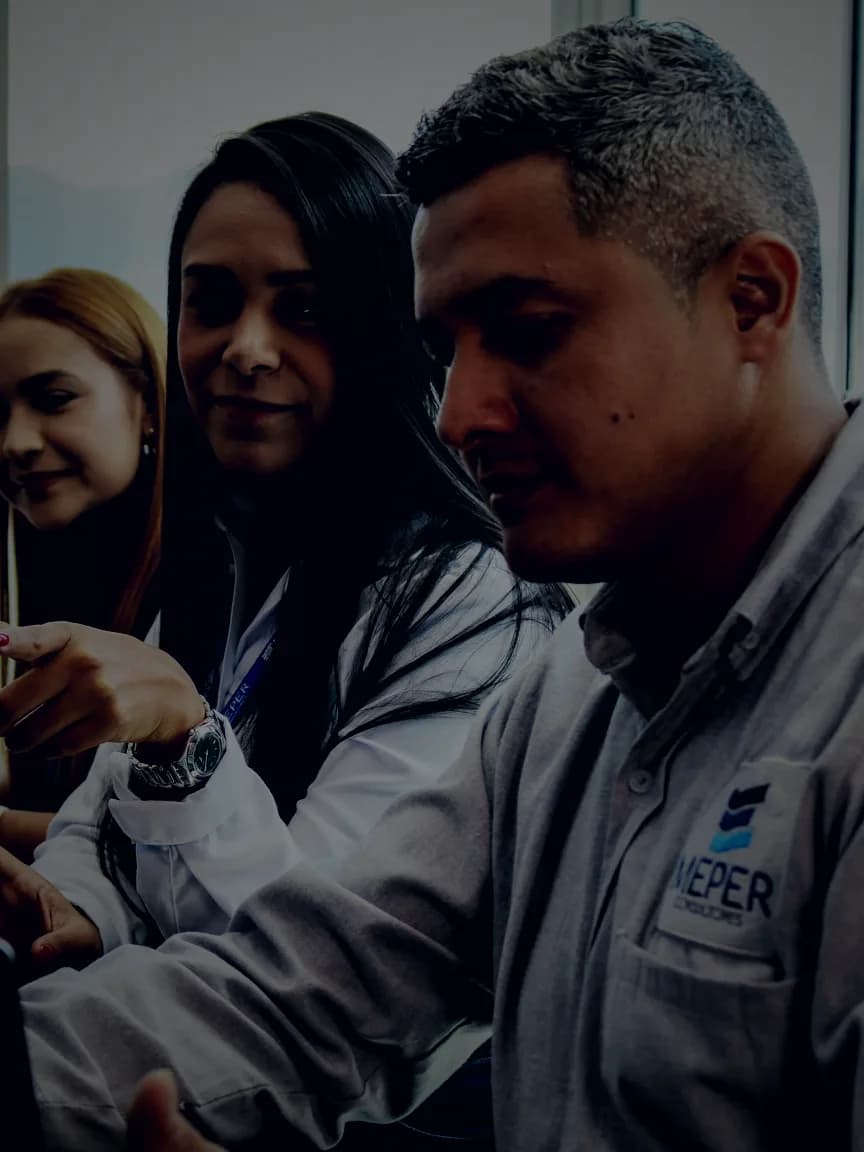 Un consultor de MEPER revisa con atención lo que una compañera señala en el teléfono, con otros dos colegas siguiendo la explicación