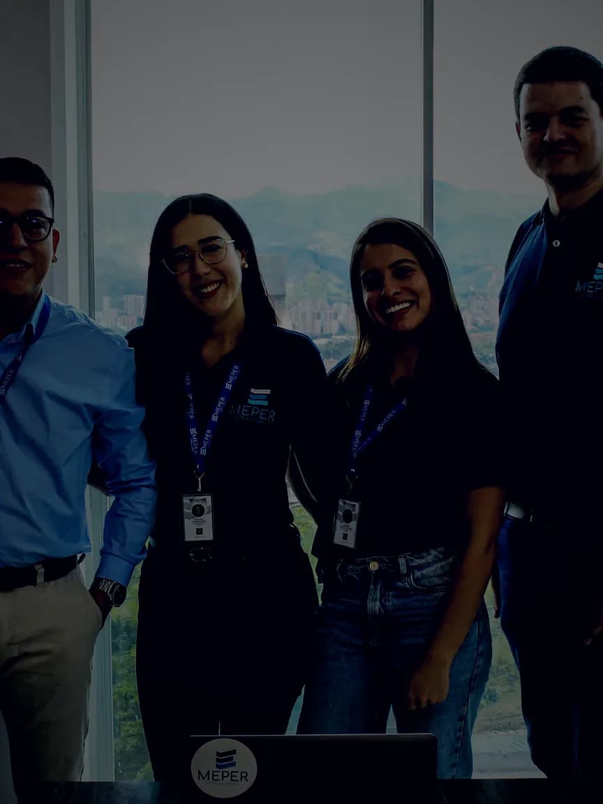Equipo de MEPER Consultores reunido junto a la ventana de su oficina en Medellín
